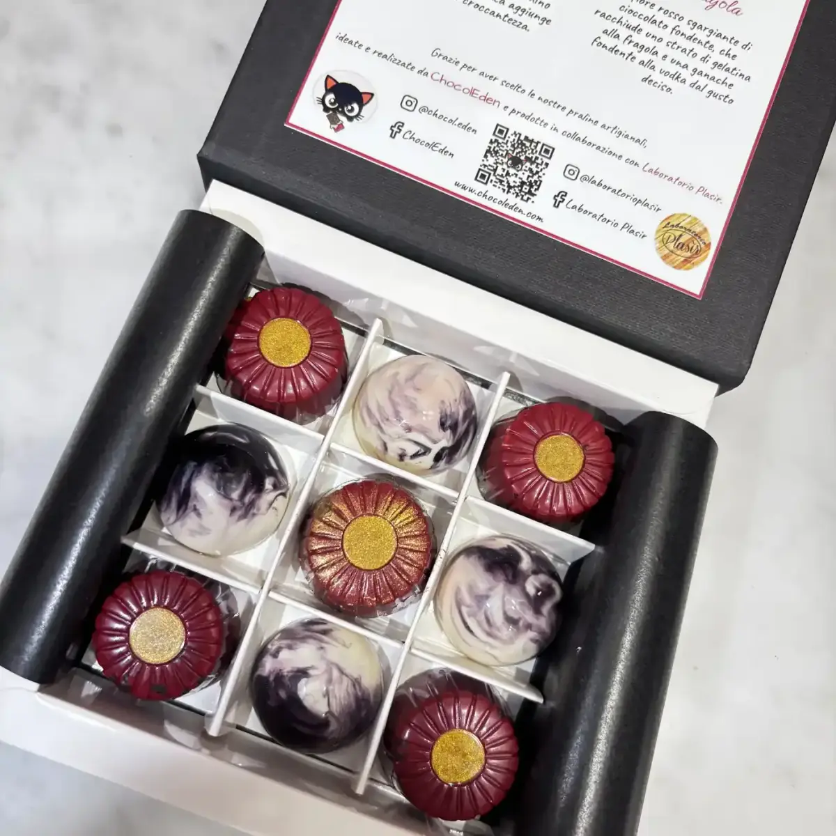 Auguri Mamma — open gift box with nine pralines: five red Fior di Fragola flowers and four marbled Ibisco with ChocolEden branding