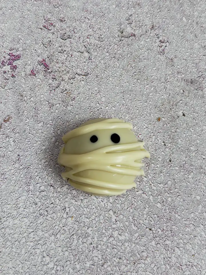 Cleo Halloween white chocolate praline decorated as a mummy with two dark eyes